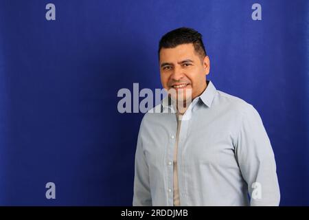 Glücklicher und erfolgreicher 40-jähriger, dunkelhaariger Latino-Mann lächelt und posiert entspannt und ruhig für die Kamera Stockfoto
