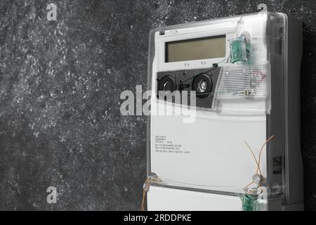Stromzähler an grauer Wand, Platz für Text Stockfoto