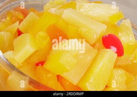 Eine köstliche Glasschüssel mit Frucht-Cocktail-Mix isoliert auf Holzhintergrund mit Kopierbereich Stockfoto