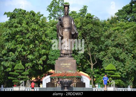 Junge Jungs spielen um die Statue von Kaiser Ly Thai To, Führer der Ly-Dynastie, in Hanoi, Vietnam , Asien; am Tempel von König Le Thai To; eine Statue des Königs, die auf einer großen Plattform steht, auf der ein Schwert steht, das auf den See zeigt. 1,2 Meter hohe Bronzestatue, erbaut 1894 von einem Führer der nördlichen Region namens Hoang Cao Khai (1850-1933). Die Statue ist eine Erinnerungslegende über den König, der das magische Schwert der heiligen Schildkröte zurückgegeben hat, was den Wunsch nach Frieden symbolisiert Stockfoto