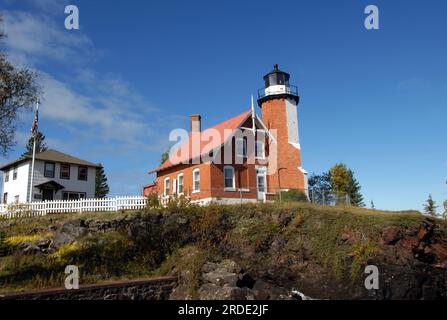Der Eagle Harbor Lighthouse und das Besucherzentrum befinden sich auf einer Klippe mit Blick auf den Lake Superior auf der oberen Halbinsel, Michigan. Der Leuchtturm ist Backsteinarchitektur und Stockfoto