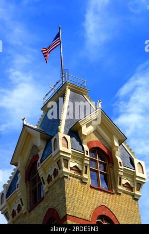 Das 120 Jahre alte Bezirksgericht aus der viktorianischen Zeit in Houghton, Michigan, ist mit rotem Sandstein und Lake Superior Copper als Dach gestaltet. Flagge f Stockfoto