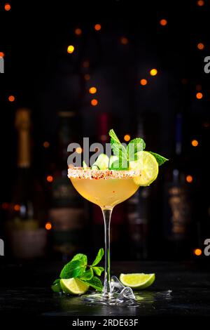 Gurke margarita alkoholisches Cocktailgetränk mit Tequila, Limettensaft, Sirup, Minze und Eis in Glas garniert mit gesalzenem Chili-Pfeffer-Rand, dunkler Backgr Stockfoto