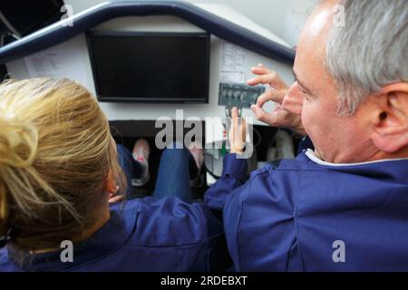 Mann und Frau in der Lehrlingsausbildung im Flugsimulator Stockfoto