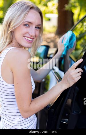 Die Frau wechselt die Scheibenwischer an einem Auto Stockfoto