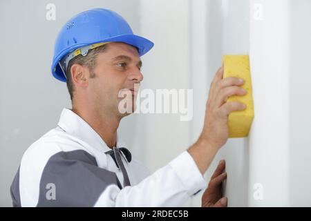 Polieren verputzte Wände mit Schwamm Stockfoto