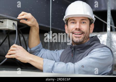 Porträt eines lächelnden Elektrikers auf der Baustelle Stockfoto