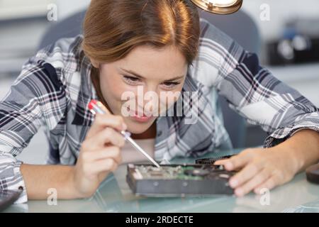 Frau repariert ein elektronisches Gerät Stockfoto