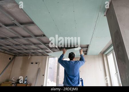 Drywall Installers. Men holding a gypsum board figured cut Stockfoto