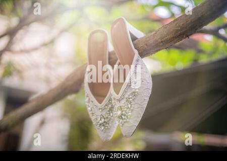 Hochzeitsschuhe mit spitzen Zehen. Schuhe mit hohen Absätzen. Frauenfüße in luxuriösen Sommerschuhen für Damen. Elegante Hausschuhe für Damen auf dem Boden. Fash Stockfoto