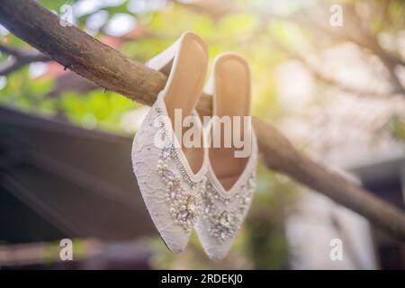 Hochzeitsschuhe mit spitzen Zehen. Schuhe mit hohen Absätzen. Frauenfüße in luxuriösen Sommerschuhen für Damen. Elegante Hausschuhe für Damen auf dem Boden. Fash Stockfoto