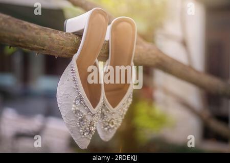 Hochzeitsschuhe mit spitzen Zehen. Schuhe mit hohen Absätzen. Frauenfüße in luxuriösen Sommerschuhen für Damen. Elegante Hausschuhe für Damen auf dem Boden. Fash Stockfoto
