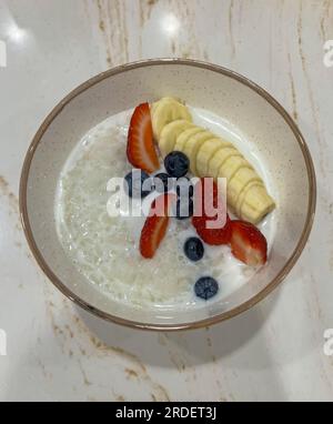 Reisbrei mit Banane, Erdbeere und Heidelbeere Stockfoto