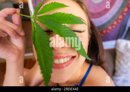 Ein wunderschönes braunes Model raucht Marihuana in der Privatsphäre ihres eigenen Zuhauses Stockfoto