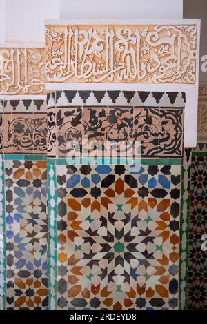 Marokko: Dekorative Zellij-Mosaikfliesen (unten) mit Koranversen (oben), Ben Youssef Madrasa (Medersa Ben Youssef), Medina von Marrakesch, Marrakesch. Der Sultan der Saadier-Dynastie, Abdallah al-Ghalib Billah (1517 - 1574), baute die Madrasa im Jahr 1565 (972 AH). Es war einst das größte islamische College im Maghreb (Nordwestafrika). Stockfoto