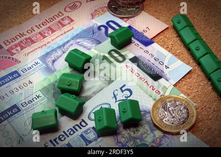 Unterbringungskosten (Kauf oder Miete) in Nordirland, Sterling-Banknoten, Münzen, Monopolhäuser Stockfoto