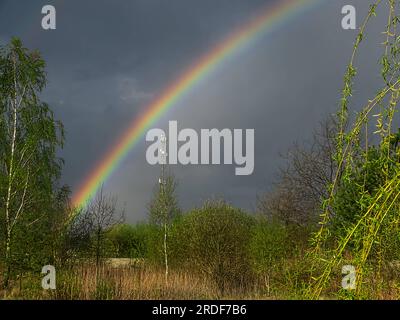 Ein Regenbogen am bewölkten Himmel. Stockfoto