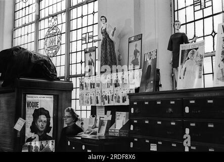 Derry und Toms, das Kaufhaus in der Kensington High Street. Die Dressbildner-Abteilung. Eine Ladenassistentin, die hinter einem Tresen steht. London, England, ca. 1968. 1960S GB HOMER SYKES Stockfoto
