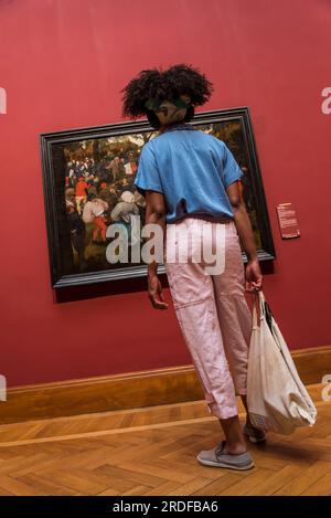 Besucher, die ein Gemälde von Pieter Bruegel, dem Ältesten, „der Hochzeitstanz“, das Museum der alten Meister, das Königliche Museum der Schönen Künste, Antwerpen, Belgien betrachten Stockfoto