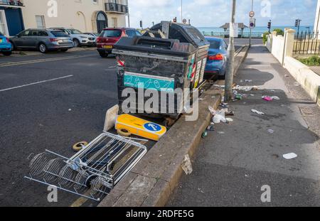 Müll, einschließlich eines Hinweisschilds in Richtung Verkehr, links auf der Brighton Street bei den öffentlichen Mülltonnen, Sussex, England UK Stockfoto