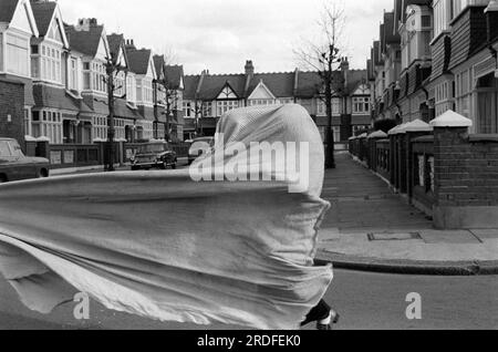 Verstecken und suchen. Kinder spielen draußen auf der Straße, mit einer Decke, spielen eine Art Versteck und suchen. Colwith Road, Fulham, London, England 1972 1970er Jahre, Großbritannien HOMER SYKES Stockfoto