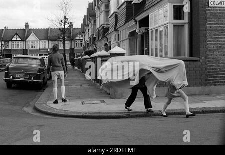 Verstecken und suchen. Kinder spielen draußen auf der Straße, mit einer Decke, spielen eine Art Verstecken und Suchen. Colwith Road, Fulham, London, England 1970. 1972 UK HOMER SYKES . Stockfoto