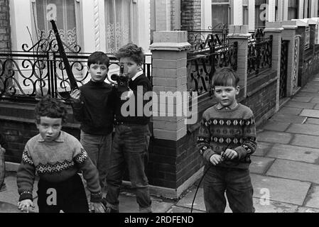 Junge Jungs spielen auf der Straße mit Spitzenköpfen. - Schießen auf Passanten vorbei. Chelsea, London, England um 1970. 1970er Jahre UK HOMER SYKES Stockfoto