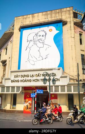 Das gigantische Porträt von Vietnams revolutionärem Führer Ho Chi Minh, der ein Kind auf dem alten Trang Tien Post Office Gebäude in Hanoi, Vietnam, hält. Der CO Stockfoto