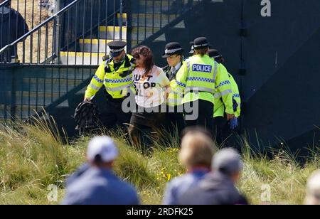 Ein Just Stop Oil Demonstranten wird von der Polizei am zweiten Tag der Open im Royal Liverpool, Wirral, mitgenommen. Bilddatum: Freitag, 21. Juli 2023. Stockfoto