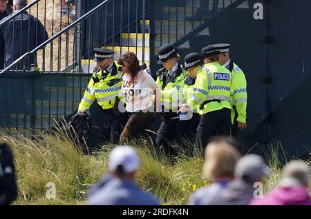 Ein Just Stop Oil Demonstranten wird von der Polizei am zweiten Tag der Open im Royal Liverpool, Wirral, mitgenommen. Bilddatum: Freitag, 21. Juli 2023. Stockfoto