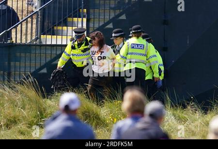 Ein Just Stop Oil Demonstranten wird von der Polizei am zweiten Tag der Open im Royal Liverpool, Wirral, mitgenommen. Bilddatum: Freitag, 21. Juli 2023. Stockfoto
