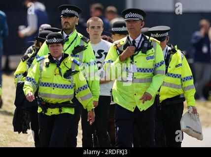 Ein Just Stop Oil Demonstranten wird von der Polizei am zweiten Tag der Open im Royal Liverpool, Wirral, mitgenommen. Bilddatum: Freitag, 21. Juli 2023. Stockfoto