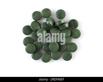Chlorella-Tabletten sind Nahrungsergänzungsmittel. Spirulina in Form von Pillen. Runde grüne Pillen auf weißem Hintergrund, Draufsicht. Haufen Spirulina-Tabletten Algennutr Stockfoto