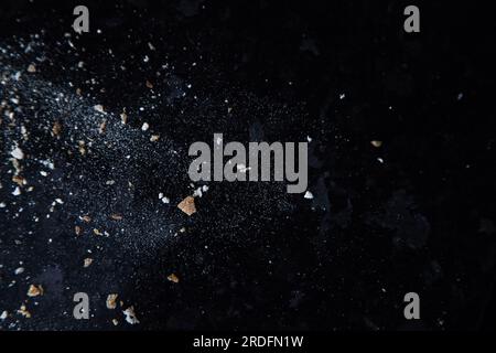 Abstraktes Bild mit Mehl und Brotkrumen auf dunklem Hintergrund. Konzeptionelles Bild, Anspielung auf Raum und Kosmos, Unbekanntes, Licht und Dunkelheit. Stockfoto