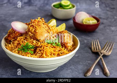 Indisches Hühnchen Biryani mit Zwiebeln, Gurke und Zitrone, Nahaufnahme aus kleinen Winkeln Stockfoto