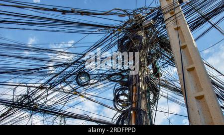 Verhedderte elektrische Leitungen, Chaos im Stromversorgungssystem der Stadt. Stockfoto