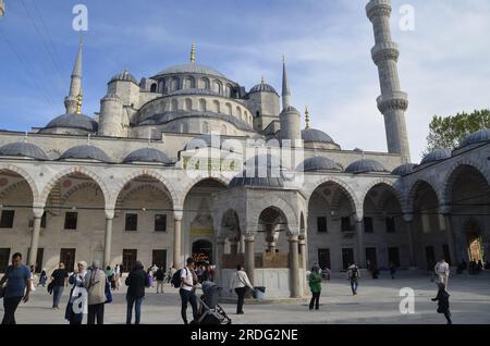 Istanbul Türkei, Mai 2023 Blaue Moschee, Fassade vom Innenhof, Brunnen, Touristen und Inschrift, Kuppel und Minarette. Stockfoto