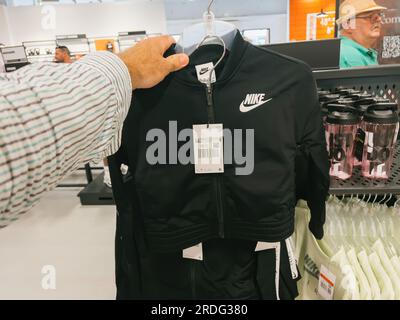 Roppenheim, Frankreich - 11. Juli 2023: Ein Mann wählt Nike Damenbekleidung in einem Outlet-Store aus und gibt so einen persönlichen Einblick in das Erlebnis. Stockfoto