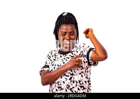 Eine schöne, reife Frau, die vor weißem Hintergrund steht, Parfüm aufträgt und lächelt. Stockfoto