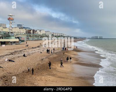 Brighton, Großbritannien - November 12. 2022: Menschen am Kiesstrand im Winter. Stockfoto