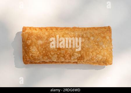 Apfelkuchen mit knuspriger Kruste und einer heißen, leckeren Füllung. Das Bild zeigt die Delikatesse mit selektivem Fokus auf weißem Hintergrund. Stockfoto