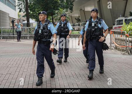 Hongkong, China. 21. Juli 2023. Polizeibeamte patrouillieren vor dem Gerichtsgebäude. Am 21. Juli 2023 erscheint Ronson Chan, eine prominente Journalistin aus Hongkong und Vorsitzender der Hong Kong Journalists Association, vor dem West Kowloon Law Courts Building, um sich der Anklage zu stellen, einen Polizeibeamten bei der ordnungsgemäßen Erfüllung seiner Pflichten und einen Amtsträger behindert zu haben. Die Gerichtssitzung ist die Fortsetzung eines teilweise verhandelten Falles, in dem Chan involviert ist. Kredit: SOPA Images Limited/Alamy Live News Stockfoto