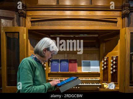 Corstorphine Old Parish Church, Edinburgh, Schottland, Großbritannien, 21. Juli 2023. Scotland Churches Trust Recording Project: Die Kirche von Schottland besitzt fast die Hälfte der Kirchen des Landes und überprüft derzeit ihr Immobilienportfolio, da weniger Gläubige anwesend sind. Das Projekt versucht, Inhalte aufzuzeichnen, bevor sie verloren gehen. Diese Kirche ist derzeit nicht bedroht und gibt den Freiwilligen die Möglichkeit, die Verwendung der App zu üben, um Inschriften zu messen, aufzuzeichnen und Objekte und Merkmale zu dokumentieren. Abbildung: Freiwilliger Sybil Cavanagh zeichnet Informationen über das Organ auf. Kredit: Sally Anderson/Alamy Live News Stockfoto