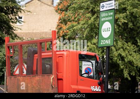 Ein Lastwagen fährt am 21. Juli 2023 in London, England, am South Circular am Tulse Hill an einem ULEZ-Schild (Ultra Low Emission Zone) vorbei. Der Londoner Bürgermeister Sadiq Khan, der von seinem konservativen Vorgänger Boris Johnson vorgestellt wurde, möchte die ULEZ-Region auf ein größeres London ausdehnen, um ältere Fahrzeuge wie verschmutzende Dieselfahrzeuge und Benzinfahrzeuge zu erschließen, eine umstrittene Luftqualitätspolitik zur Senkung giftiger Emissionen, die der Gesundheit von 1 von 10 Kindern schaden. Fahrer von nicht befreiten Fahrzeugen können nach Zahlung einer Tagesgebühr von £12,50 USD in die ULEZ einreisen – oder sie müssen eine Gebühr von £160 USD zahlen. Stockfoto