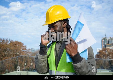 Afrikanischer Bauarbeiter, der die reflektierende Jacke trägt, während er  auf einer Baustelle arbeitet Stockfotografie - Alamy