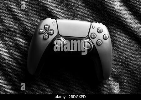 Brecht, Belgien - 14. juli 2023: Ein schwarz-weißes Topdown-Porträt eines offiziellen PS5-Game-Controllers, der auf einer Couch liegt und mit dem gespielt werden kann. Die PL Stockfoto
