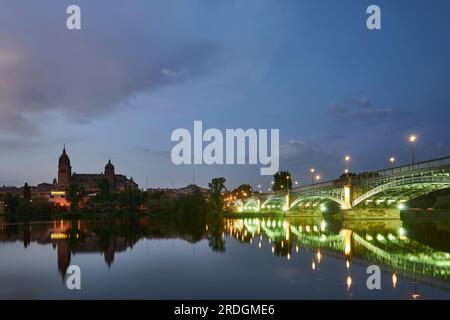 Die Kathedrale von Salamanca bei Nacht und die Enrique Esteban Brücke Blick vom Tormes Fluss, Salamanca Stadt, Spanien, Europa. Stockfoto