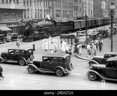 Syracuse, New York: ca. 1933. Der Empire State Express, der sich auf die Überquerung der South Salina Street, der Hauptgeschäftsstraße von Syracuse, vorbereitet. Stockfoto