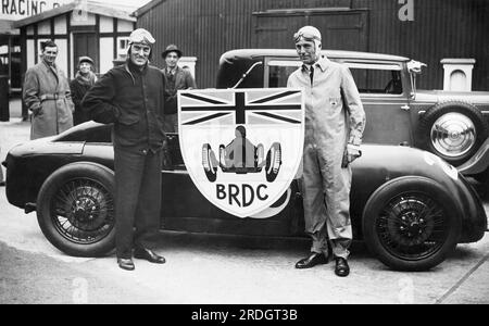 Surrey, England: 9. September 1931 die britischen Rennfahrer Sir Malcolm Campbell und Earl Howe tragen das neue Abzeichen des British Racing Drivers Club auf der Brooklands Race Track. Stockfoto