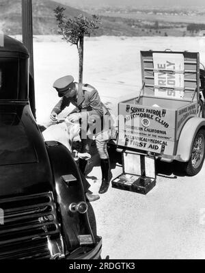 Los Angeles, Kalifornien: c... 1930 Ein Mitglied der Dienstpatrouille des Automobile Club von Südkalifornien leistet erste Hilfe für einen verletzten Autofahrer. Stockfoto